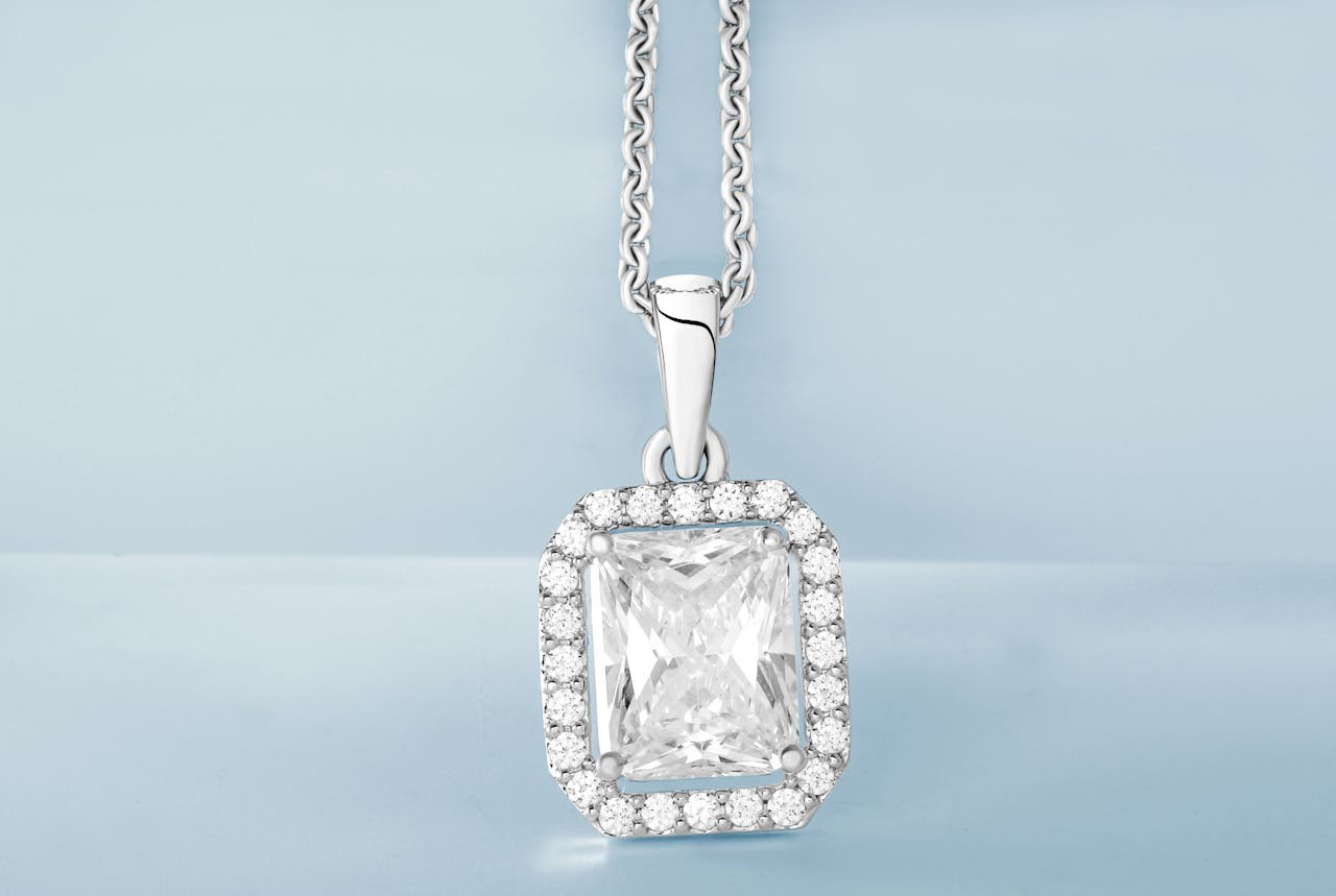 Luxurious diamond pendant necklace displayed against a soft blue backdrop.